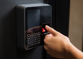 A woman opens the door with her fingerprint. Modern keyless entry lock